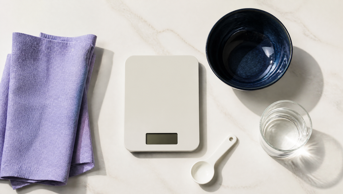 Overhead flat lay of a kitchen scale, measuring spoon and glass of water, creatine dosage